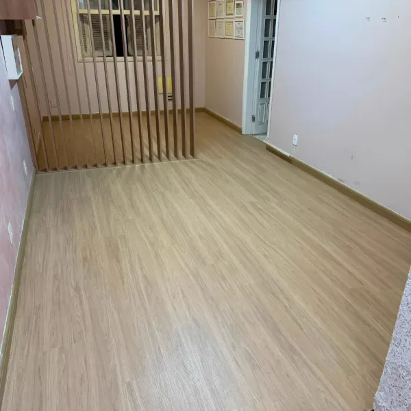 Ambiente renovado com piso laminado Eucafloor e integração com rodapés